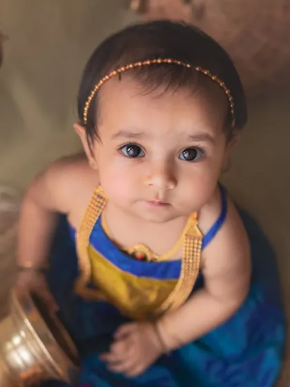A beautiful top-down portrait that captures the baby's curious gaze. The ethnic styling and props create a unique and artistic composition.