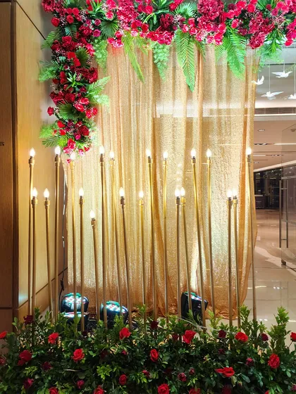 A detail shot of our candle wall setup. The warm glow of the bulb-topped golden rods against a shimmering gold curtain creates a rich and inviting atmosphere.