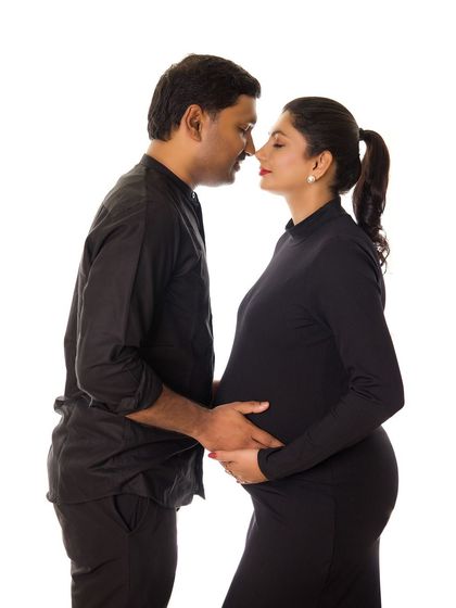 An intimate nose-to-nose pose that I love for maternity sessions. The all-black outfits against a white background create a striking and classic portrait.