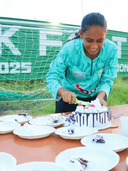 A coach happily cuts and serves cake during our club's birthday celebrations.