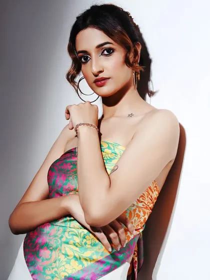 A chic and colorful look. The makeup is clean and classic, allowing the vibrant, patterned top to be the star of the show.