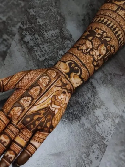 The full arm view of the couple portrait mehndi, showing how the figures are integrated into a larger design of traditional motifs.