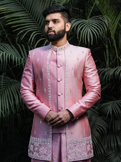 This client is the picture of modern elegance in a lustrous pink silk Indo-Western jacket. The ensemble features subtle, intricate embroidery along the placket and hem, offering a sophisticated and contemporary choice for a wedding guest.