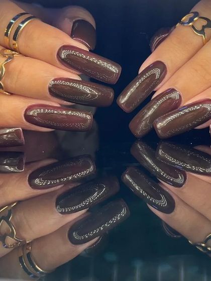 A deep brown cat-eye effect on long, square-shaped nails for a sophisticated look.