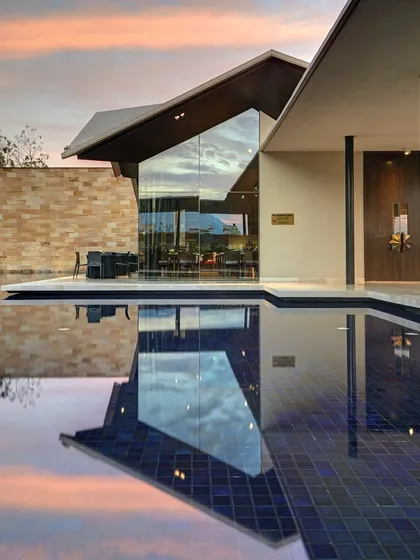 The Lotus Cafe at the Dasavatara Hotel in Tirupati, where the modern, angular roof reflects on the water at dusk, creating a dialogue between the structure and its environment.