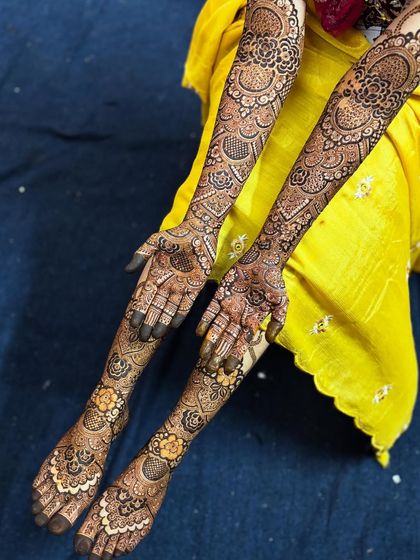 A beautiful shot of the bride's hands and feet together. The floral patterns on the feet perfectly match the style of the hand mehendi.