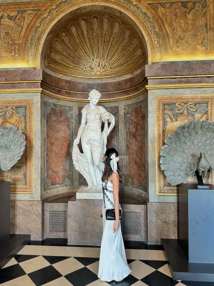Admiring the classical sculptures at Versailles. My outfit's timeless black and white palette feels perfectly in tune with the artistic and historical surroundings.