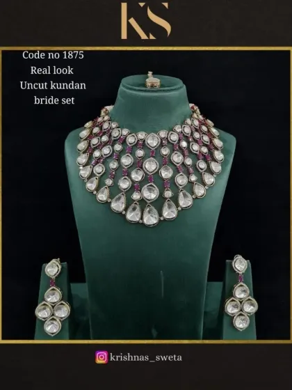 This real-look uncut Kundan set is accented with deep ruby red stones, adding a touch of classic bridal color to the design.