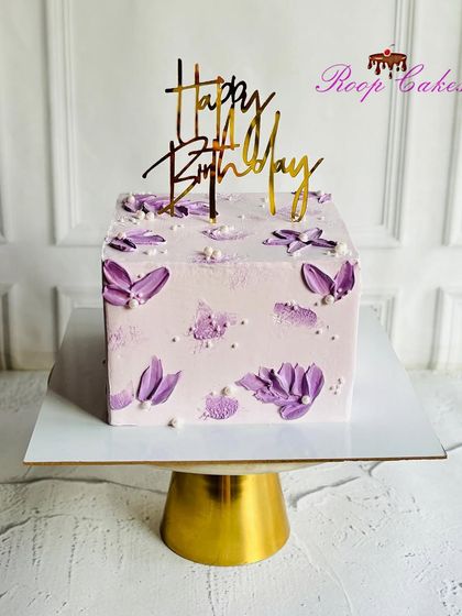 Art you can eat. This dreamy square cake features purple palette knife strokes on a soft lavender base, creating a beautiful, abstract floral design.