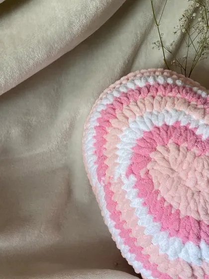 A close-up shot of our plush heart pillow, showing the soft texture of the chunky yarn. This Y2K aesthetic pillow is a cozy and cute addition to any decor.