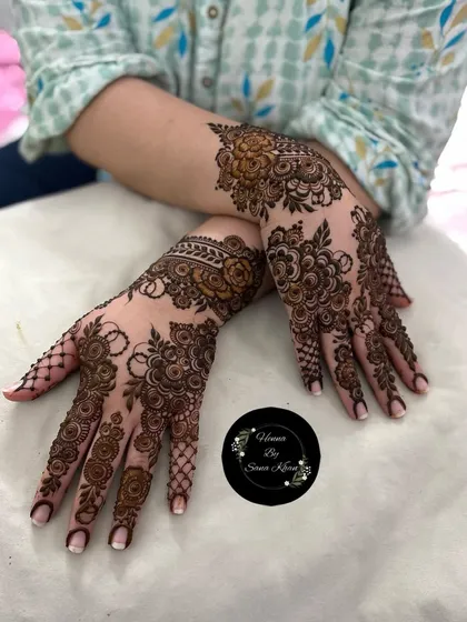 A beautiful example of a heavy floral design that extends from the fingers to the wrist. The different sizes of roses and leaves create a natural, garden-like effect on the hands.