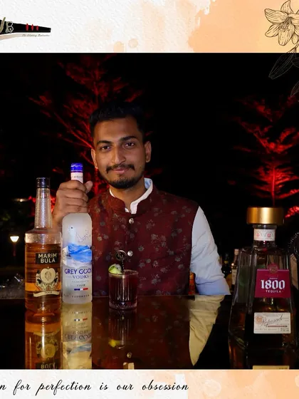 Our mixologist with a selection of premium spirits, highlighting the quality ingredients we use in all our drinks.