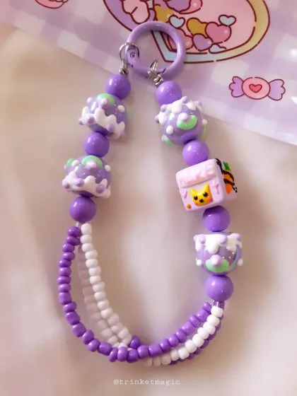 A closer look at the purple beaded charm, highlighting the detailed cartoon and cake-themed beads that make it so unique.