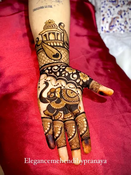 A traditional design with a modern twist, featuring a beautifully decorated elephant on the palm and a peacock in a jharokha on the wrist.