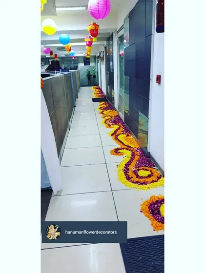 A detailed look at the winding floral rangoli path we created in the office corridor. Using fresh marigold and rose petals, this traditional floor art adds color and a festive feel throughout the office.