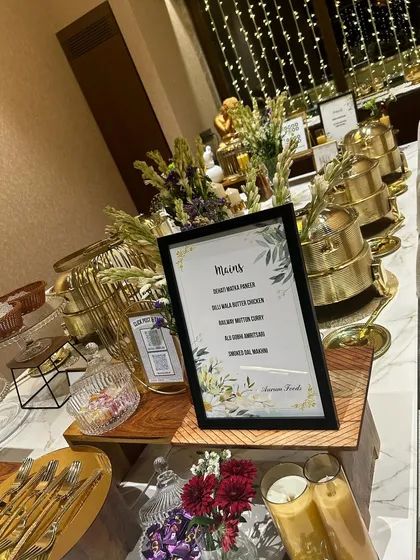 An elegant buffet setup for a house party, featuring our signature gold chafing dishes and a clearly displayed menu. We handle every detail, including the presentation, so you can focus on enjoying the moment with your guests.