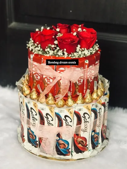 A unique alternative to a traditional birthday cake. This two-tiered chocolate tower is made from KitKats and Galaxy bars, topped with fresh roses for an elegant and delicious centerpiece.