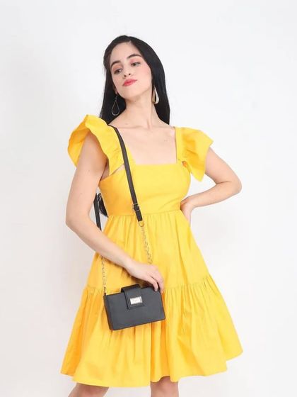 A model in a bright yellow dress with a handbag, a classic e-commerce shot that clearly shows the product and an accessory.
