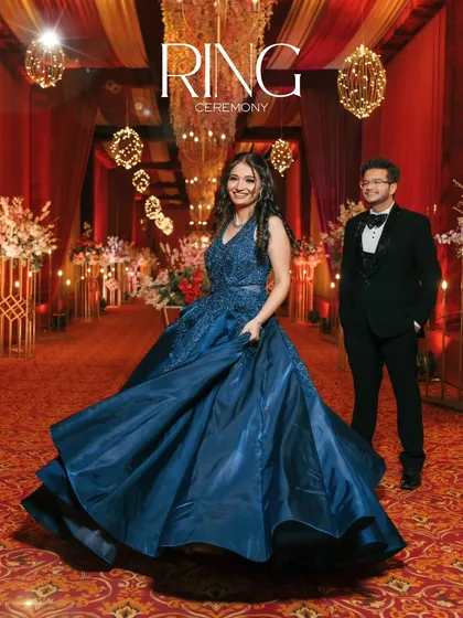 A grand and glamorous shot of Aaditya and Mehak at their ring ceremony. The bride's flowing blue gown and the opulent decor create a fairytale like scene.