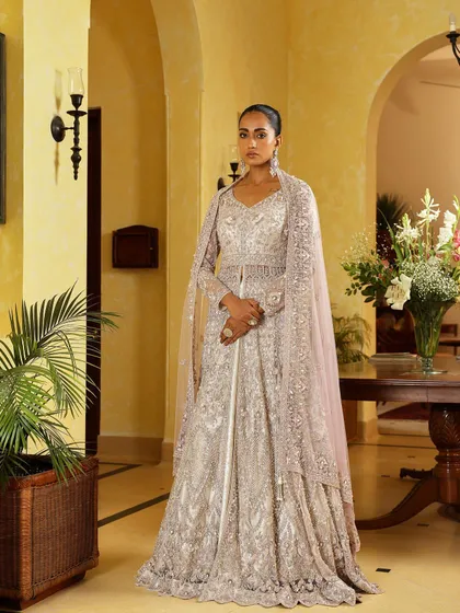 A solo shot of a magnificent floor-length gown with a matching embroidered cape. This is a perfect example of a modern reception outfit I would style for a bride seeking glamour and sophistication.