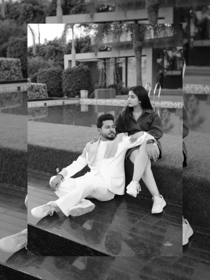 A chic black and white photo of a couple relaxing by a pool, capturing a moment of quiet connection in a modern, luxurious setting.