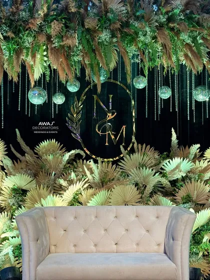 The stage setup before the event, showcasing the plush sofa and the lush arrangement of pampas grass and dried florals.