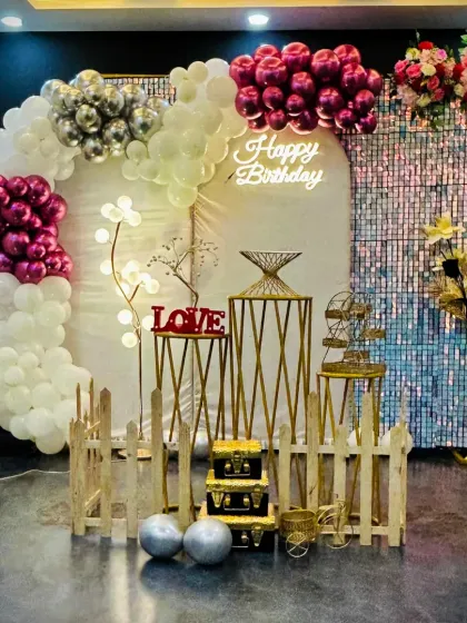 This wide shot displays the complete birthday arrangement with a balloon half-arch, shimmer wall, and decorative props. The combination of chrome and pastel balloons gives it a modern and elegant feel, suitable for any stylish birthday bash.