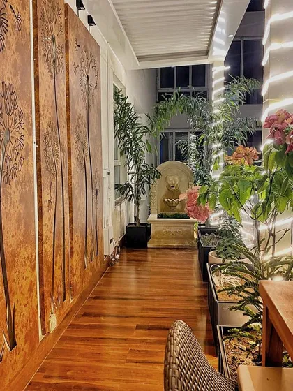 At night, our designs truly come to life. Here, custom-made corten steel panels with laser-cut designs are backlit for a dramatic effect, while uplighting on the bougainvillea and a gentle stone water feature create a warm and magical ambiance.