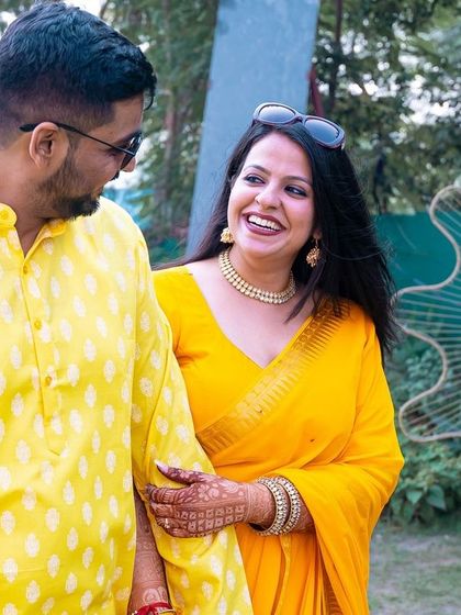 A happy, sun-drenched walk during a Haldi function. The vibrant yellow outfits and bright smiles radiate pure joy.