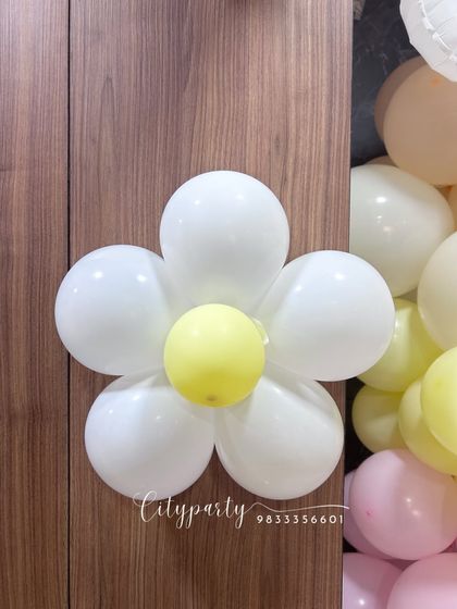 A close-up of a daisy flower balloon we crafted from simple white and yellow balloons. These custom shapes can be added to any arrangement to match your theme.