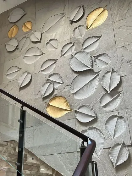 We believe stairways are an opportunity for art. This inspirational image shows a stunning mural of cascading leaves on a stone-clad wall, with select leaves finished in gold to catch the light. It's a perfect example of turning a transitional space into a feature.