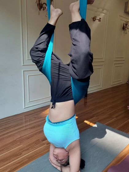 A student holding a supported headstand. The silks provide the stability needed to work on inversions safely and build confidence.