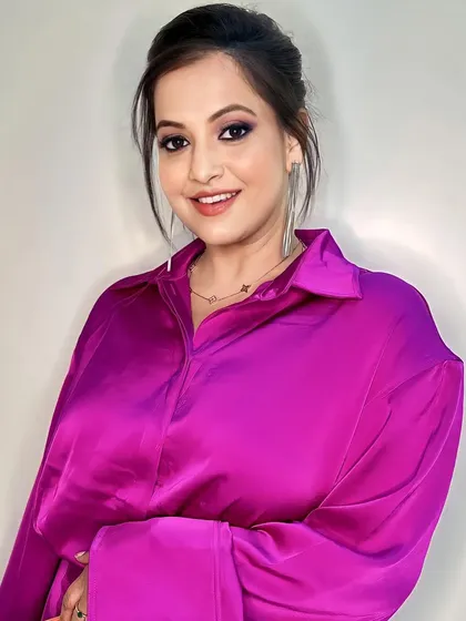 A full-face view of this gorgeous party look. The glowing skin and neatly tied bun draw attention to her eyes and the vibrant color of her outfit.