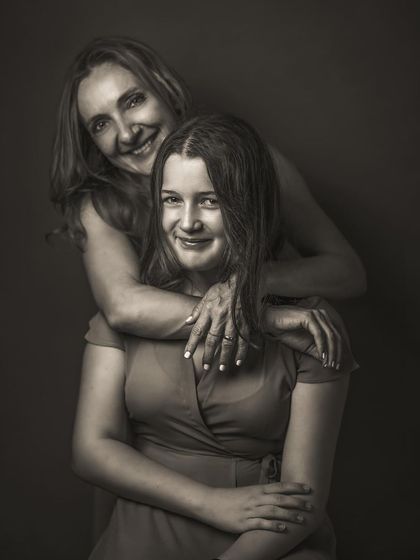 The joy in this mother-daughter portrait is palpable, and the black and white edit makes it feel classic and timeless. The focus is on their connected smiles and the warmth of the embrace, a beautiful memory preserved forever.