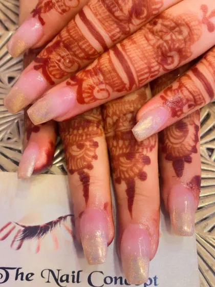 A subtle and shimmery set of nails that looks beautiful with bridal mehendi. The sheer, pearlescent polish adds a touch of elegance without overpowering the henna art.
