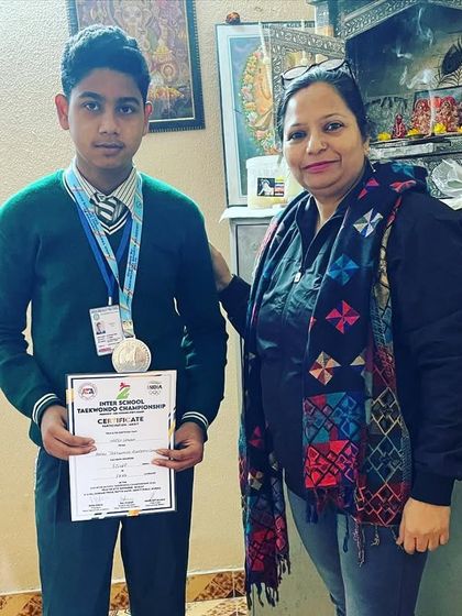 This student proudly holds his certificate and medal from the inter-school championship.