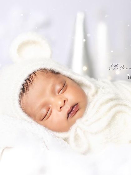 A close-up of a tiny, sleeping snowflake. The knitted bonnet with little ears adds a touch of whimsy to this peaceful newborn portrait, highlighting their delicate features.