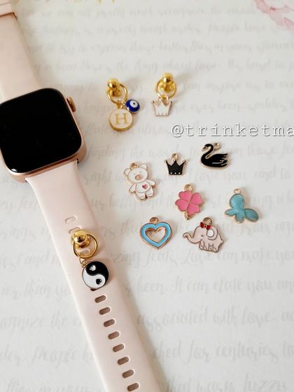 Smartwatch charms are here. This image shows how you can add cute enamel charms like a yin-yang, teddy bear, or crown to your smartwatch band.