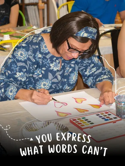 A student is completely absorbed in her watercolor painting, carefully adding details. Art allows you to express what words sometimes cannot.