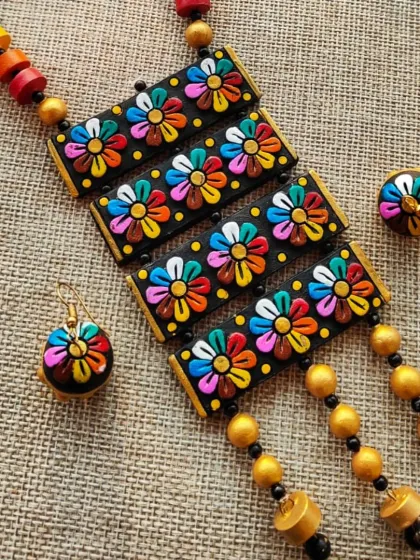 A closer view of the rectangular floral pendant necklace. You can see the 3D effect of the flowers and the small, dangling beads that add movement to the piece.