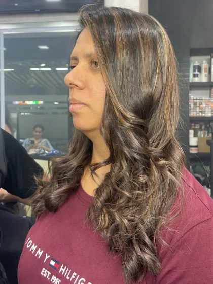 This client's hair shows a mix of caramel and golden highlights, creating a warm and inviting color palette.