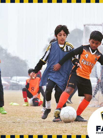 A player shields the ball from a defender during a competitive training game.