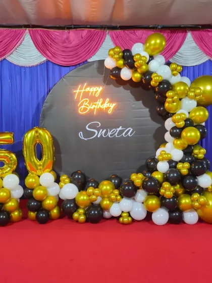 A closer look at the 50th birthday decor, showing the detail in the balloon arch and the custom backdrop. We use a mix of chrome and matte balloons to create texture and visual interest for your milestone event.