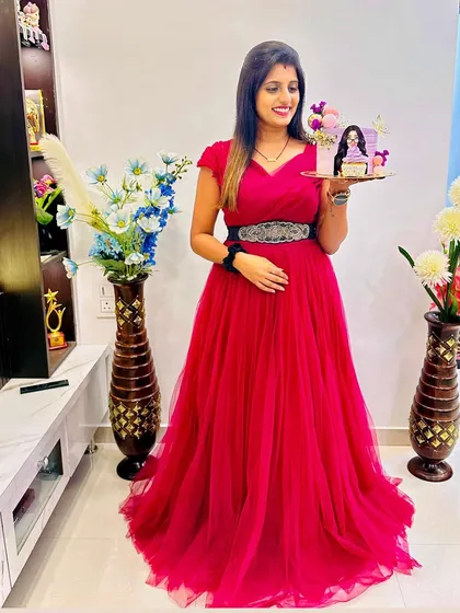 A gorgeous wine-colored ball gown for a special celebration. This client looks radiant holding a custom cake, making her birthday even more memorable.