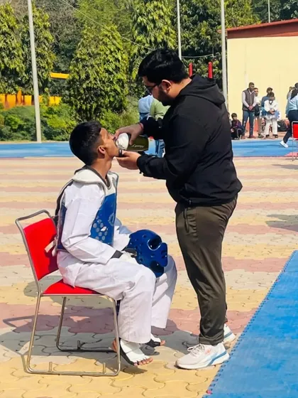 A crucial moment between rounds. Here, I'm providing tactical advice and support to our fighter Ansh during the Delhi Olympic Games. We focus on both physical strength and mental toughness to ensure our athletes are always ready.