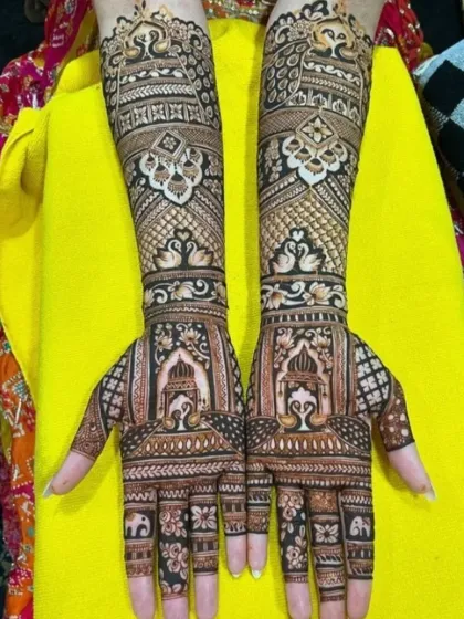 For the lover of classic designs, this intricate bridal mehandi is filled with traditional motifs. It features symmetrical patterns of jharokhas, peacocks, and swans, showcasing fine line work and a dense, rich application.