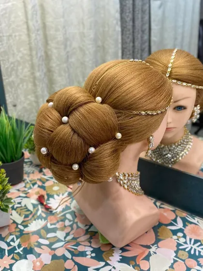 A side profile of the large woven bun, showing its clean lines and elegant shape. This is a style I often teach in my advanced hairstyling masterclasses.