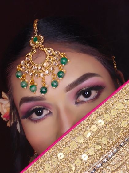 An artistic shot focusing on the beautiful eye makeup and maang tikka.