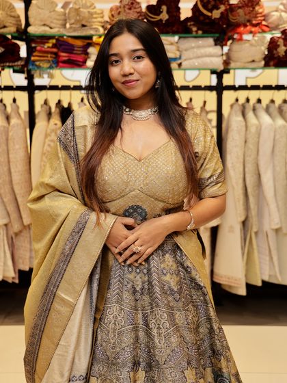 This beige and gold lehenga offers a classic and regal look. The skirt features traditional motifs, and the golden blouse adds a touch of shimmer, making it ideal for a wedding ceremony.