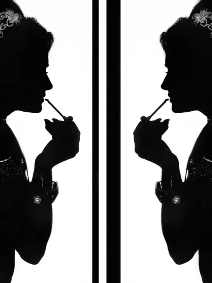 An artistic silhouette of the bride getting ready. This creative black and white shot focuses on her form and the act of preparation.